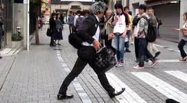 Street Art Performer in Tokyo, gets a shock from and Irishman and drops his bag.