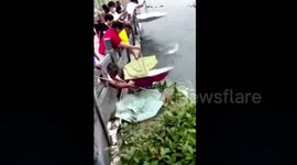 Citizens use umbrellas to catch fish that leap out of lake