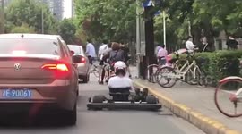 Chinese go-karter weaves in and out of traffic on busy road