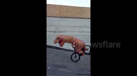 Biker stunt with dinosaur suite