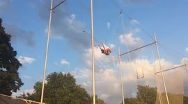 9 year old in the flying trapeze outdoors in a south London park on a hot Summer evening
