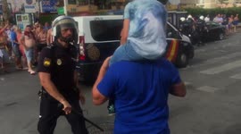 Shocking moment Spanish police officer hits man carrying child with baton