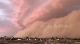Sky bathed in warm glow as sun sets over massive dust storm in southwest Arizona