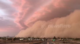 Sky bathed in warm glow as sun sets over massive dust storm in southwest Arizona