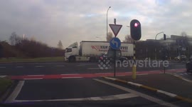 Belgian truck loses trailer full of cars at roundabout