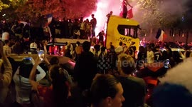 Rowdy French fans on Champs-Élysées light flares and dance on back of moving truck