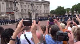 Mobiles go up for the RAF 100 bagpipers in front of Buckingham Palace