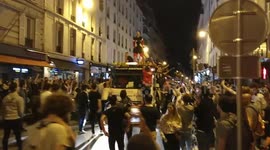 French football fans party on a recovery truck driving through rue Saint Maur in Paris