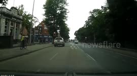 Red light cyclist in front of on coming police car.