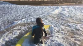 Australian girl enjoys surfing shore waves in winter