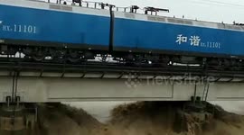Trains carrying 8,000 tons of ballast park on bridge for six hours to fight floods in China