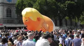 Trump blimp in Westminster square across the road from the house of commons crowd cheering thousands of people taking selfies and photos by Jim Connor
