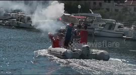 Croatians commiserate with smoke flares on a motorboat after defeat in final