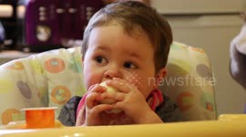 Too good to share messy kid eats an apple, face covered in yogurt.
