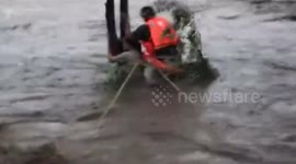 Firemen rescue woman trapped in flooded road