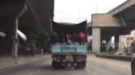 Burmese construction workers riding in truck