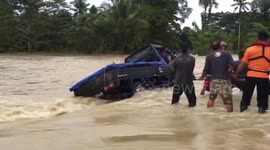 a car-rescue moment was carrying three people trapped in a massive flood