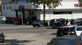 Police officers take cover behind SUV during hostage standoff in Los Angeles