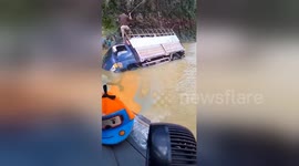 Trucks struggle through road after typhoon causes flooding in Vietnam