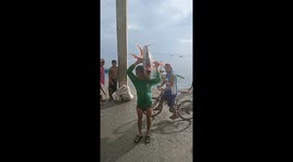 Fisherman carries giant moonfish ashore