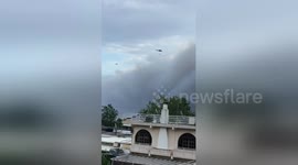 Holidaymakers film helicopters bringing water to fight fires over Attica