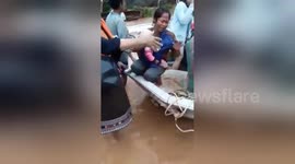 Heartbreaking moment woman holds baby after losing home in Laos flooding