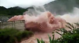 Water gushes over dam near scene of Laos flooding disaster