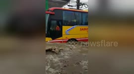 Buses struggle as Philippines storms turn road into raging river