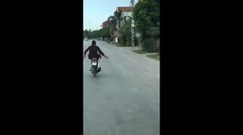 The crazy man ride motorbike by feet on the busy road