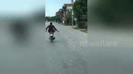 Newsflare Edit - The crazy man ride motorbike by feet on the busy road in VietNam