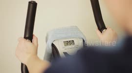 A girl exercising on a stationary bike in a gym.
