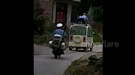 Police chase man balancing precariously on top of moving car for 12 kilometres