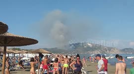 Wildfire burning in distance doesn’t ruin day for beachgoers on Greek island