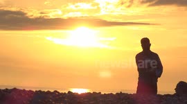 Distant silhouette of man holding baby during heatwave