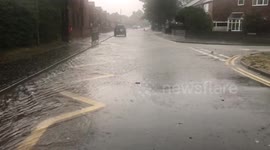 Road starts to flood as severe storms strike uk.