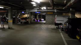 purple and pink super car blasts through the underground car park at full speed the sound is defening by jim connor