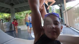 Girl goes down waterslide with camera