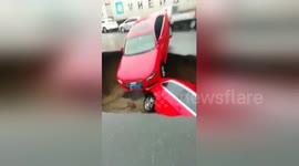 Cars drop into sinkhole caused by road collapse