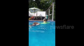 Dynamic duo! Swimming Husky pulls along a surfing Corgi
