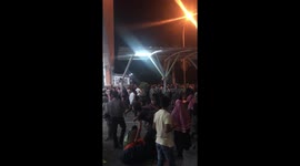 People crowd round someone receiving medical attention after Lombok airport evacuation