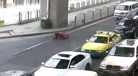 Roller skater shuttles on all fours among vehicles on busy road