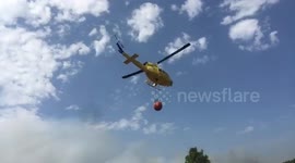Helicopters race to pick up water to fight wildfires in Spain