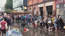 Londoners make bridge from chairs to cross giant puddle