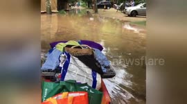 Man pushes belongings on kayak in flooded France campsite
