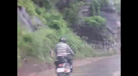 Close call: motorcyclist avoids landslide by inches