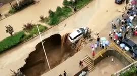 Good Samaritans team up to pull a car away from a huge sinkhole