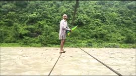 Locals balance on rope to cross flooded river in north Indian village