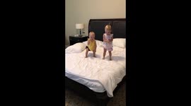 Twin babies jumping on the bed