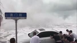 Drivers battle to stop cars from floating away as typhoon hits