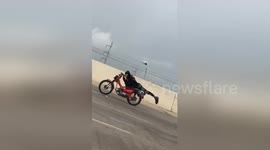Daredevil speeds down highway on motorbike clutching just his handlebars